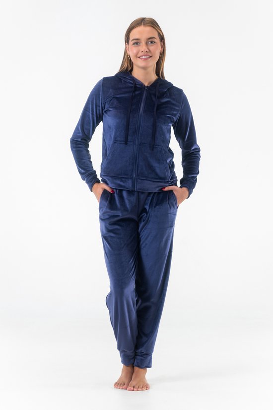 Jong model met donkerblauw fluwelen joggingpak, hoodie met rits en joggingbroek.