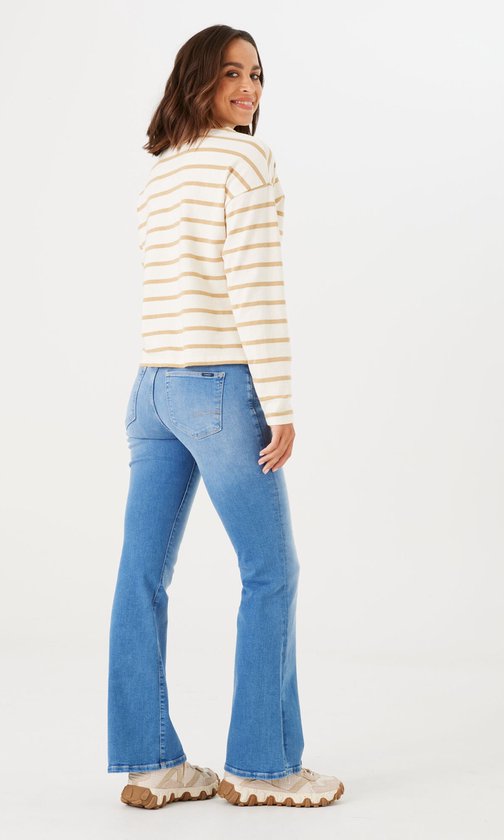 Model draagt een gestreepte trui en blauwe flared jeans, gezien van achteren.