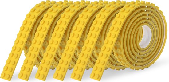 Een rol gele, flexibele speelgoedtape met nopjes, op een witte achtergrond.