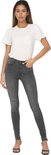 Model draagt een grijze skinny jeans met een witte korte mouw top.