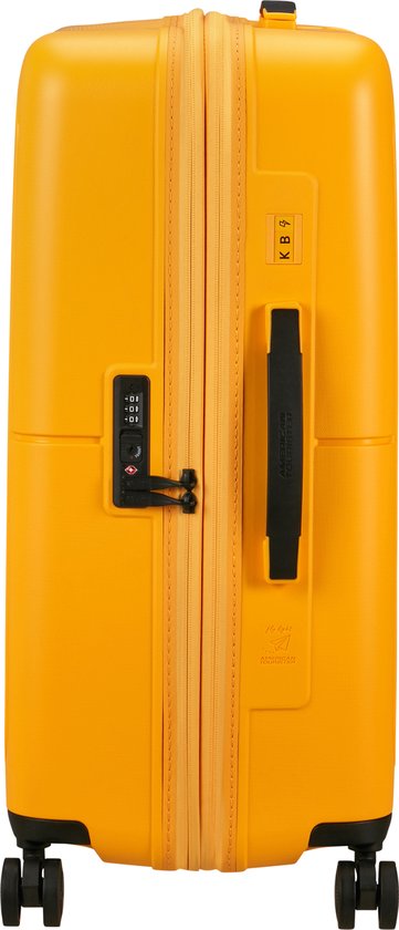 Gele American Tourister koffer met zwarte handgreep, TSA-slot en wiel.