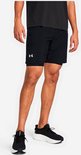 Man in zwarte sportbroek met reflecterend Under Armour logo op de linkerbroekspijp.