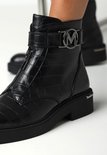 Bottines noires à imprimé crocodile, fermeture éclair et boucle argentée.