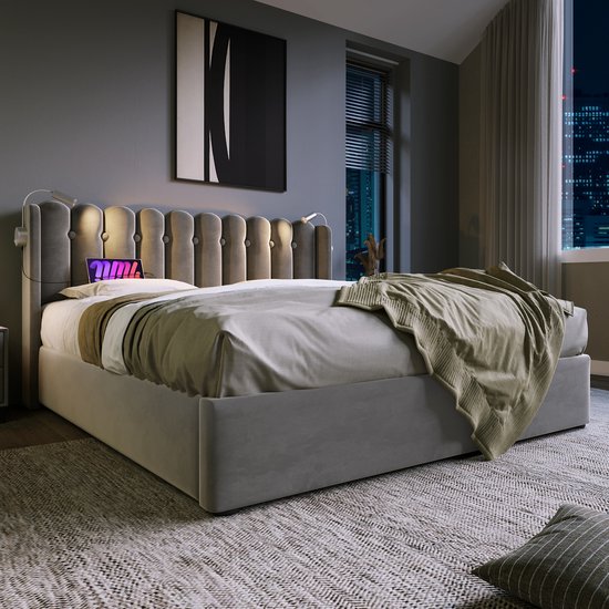 Grijze fluwelen bed met gestoffeerd hoofdbord en leeslampjes, met dekens erop.