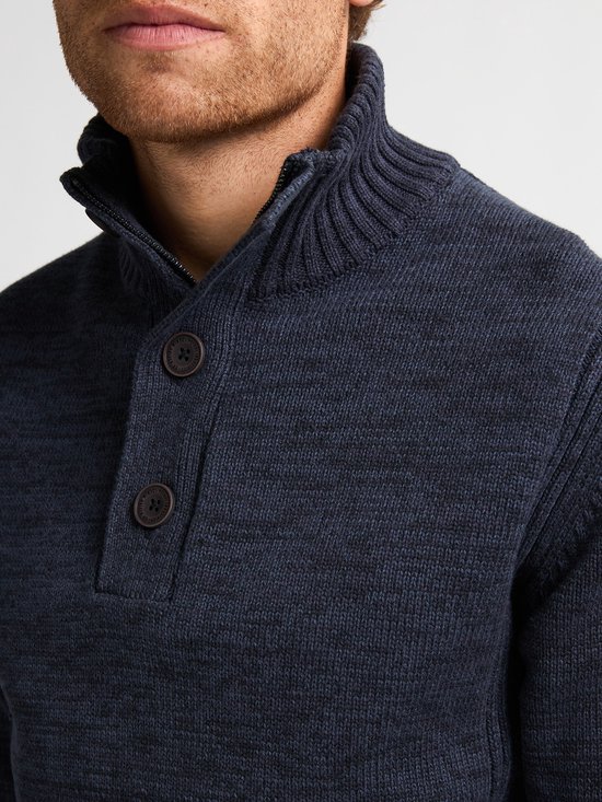 Close-up van donkerblauwe gebreide trui met opstaande kraag en knoopjes.