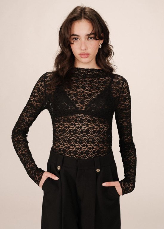 Model draagt zwarte kanten top met lange mouwen en hoge hals.