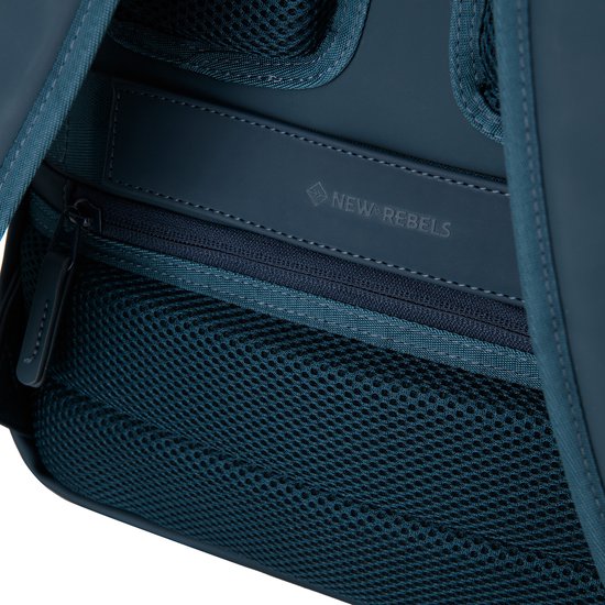 Interieur van een marineblauwe rugzak met mesh vakken en een 'NEW REBELS' logo.