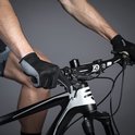 Close-up van een man die fietst, handen met zwarte en grijze fietshandschoenen op het stuur.