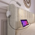 Hoofdeinde van een beige gestoffeerd bed met leeslamp en tablet-aansluiting.