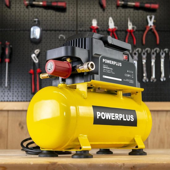Gele Powerplus compressor met zwarte bovenkant op houten ondergrond. Gereedschap op achtergrond.