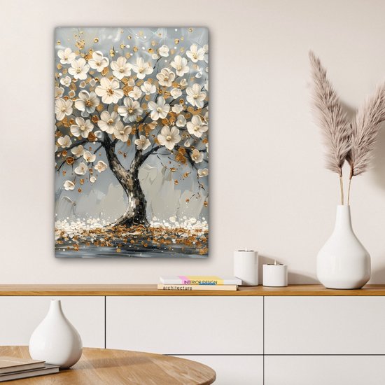 Abstract canvas schilderij met witte bloemen, gouden accenten en een donkere boom op een grijze achtergrond, boven een kast.