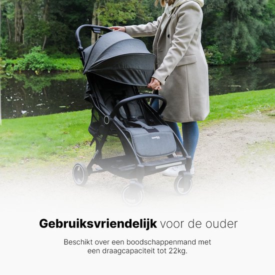 Grijze hamilton buggy met een boodschappenmand onderaan, met een vrouw die hem duwt.