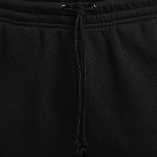 Close-up van de trekkoord sluiting van een zwarte Nike joggingbroek.