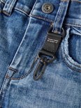Rits en knoop van een spijkerbroek met een zwarte stoffen lus met karabijnhaak en "ORG.DENIM PRODUCTS BY NAME IT" tekst.