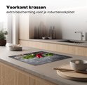 Inductiebeschermer met betonprint, met rode pepers, knoflook en kruiden, geplaatst op een aanrecht.