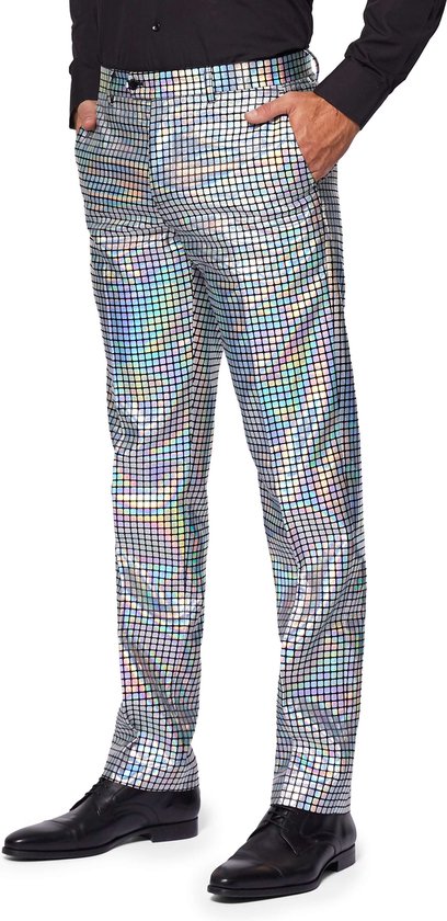 Broek met vierkante, zilverkleurige pailletten, gedragen met zwarte schoenen en een zwart overhemd.