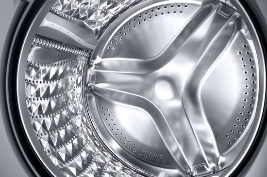 Close-up van de binnenkant van een glanzende metalen trommel van een Samsung wasmachine.
