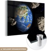 MuchoWow® Glasschilderij 60x40 cm - Schilderij acrylglas - De aarde omringt door meteoren - Foto op glas - Schilderijen