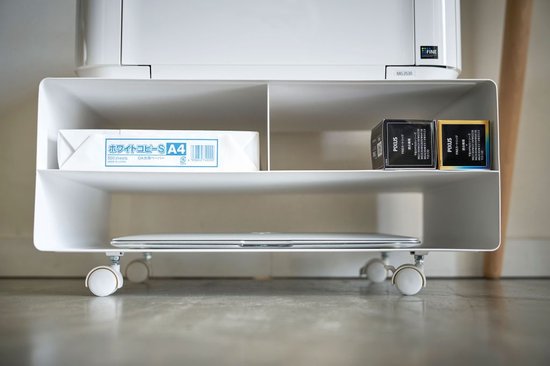 Witte printerstandaard op wielen met printer, toetsenbord, laptop en papier.