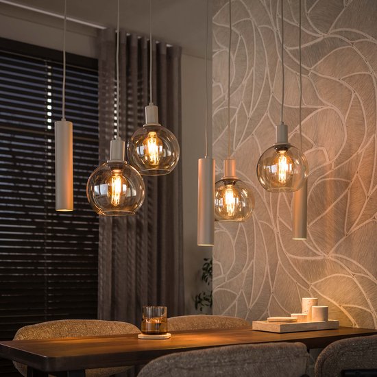 Sfeervolle beige hanglamp met verlichte glazen bollen boven een eettafel.