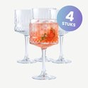 Vier cocktailglazen met brede voet, verticale ribbels en diamantpatroon. Eén glas is gevuld met een rode drank met ijs en garnering. Cirkel met '4 STUKS'.
