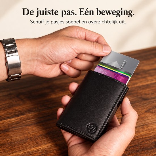 Main faisant glisser une carte argentée hors d'un porte-cartes en cuir noir.