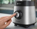 Close-up van een hand die de bedieningsknop van de Philips blender indrukt met ProBlend Plus-technologie.