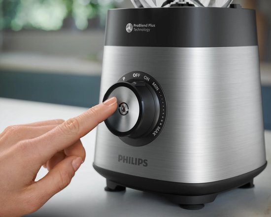 Close-up van een hand die de bedieningsknop van de Philips blender indrukt met ProBlend Plus-technologie.