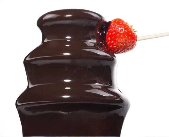Close-up van stromende chocolade op de Princess fontein, waarbij een aardbei op een prikker in de chocolade wordt gedoopt.