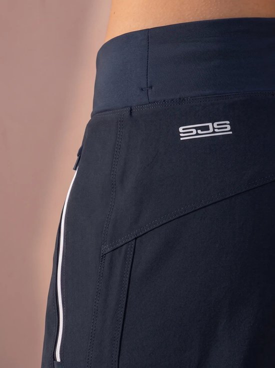 Detail van heupgedeelte van donkerblauwe broek met wit geritste zak en Sjeng Sports-logo.