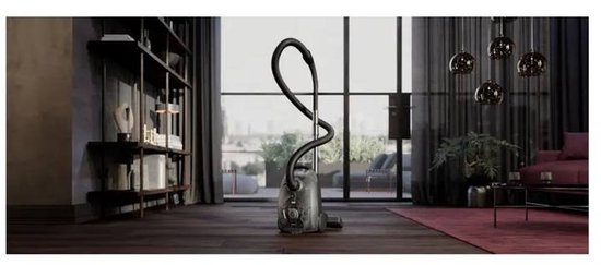 Witte AEG Clean 5000 stofzuiger in een stijlvolle woonkamer met kamerplant en planken.