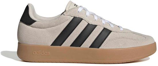 Beige Adidas sneakers met zwarte strepen op de zijkant en een gumkleurige zool. Zwarte hiel.