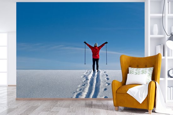 Papier peint photo vinyle - Un skieur marche avec ses bâtons de ski au sommet de la montagne largeur 350 cm x hauteur 260 cm - Tirage photo sur papier peint (disponible en 7 tailles)