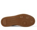 Onderkant van een zwarte sneaker met bruine zool met Maruti logo patroon.
