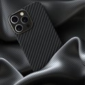 Smartphone in een grijs en zwart carbon patroon hoesje op gedrapeerde stof.