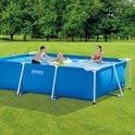 Rechthoekig blauw Intex opzetzwembad met drie kinderen die erin spelen in een groene tuin.