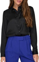 Zwarte satijnen blouse met lange mouwen en knoopjes, gedragen door een model met een blauwe broek.