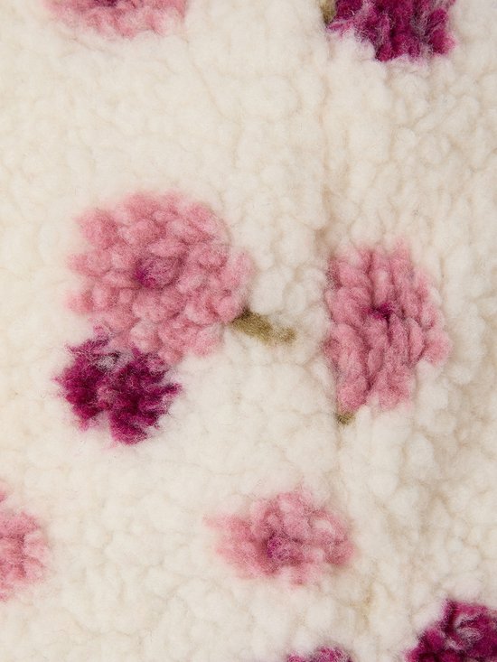 Witte, zachte sherpa stof met een geborduurde print van roze en paarse bloemen.