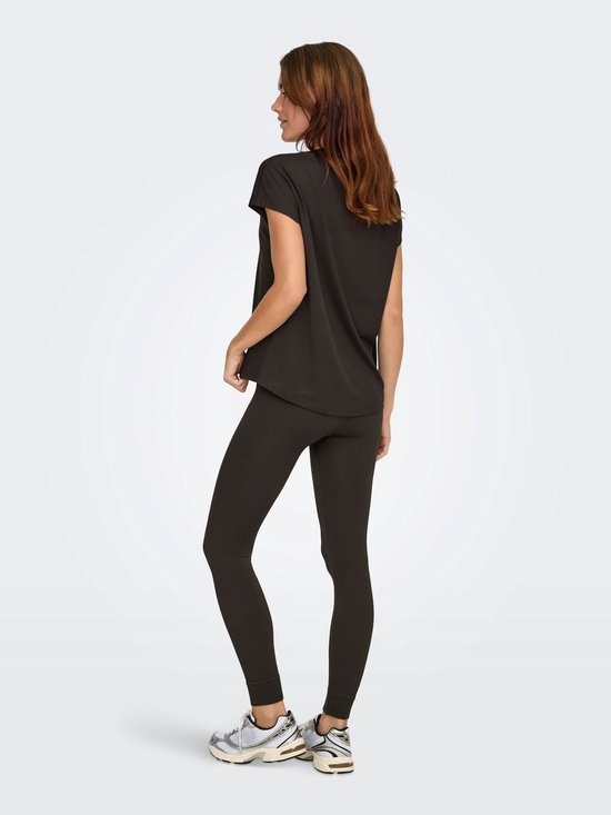 Model van achteren gezien in een donkerbruin t-shirt met korte mouwen en een legging.