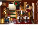 LEGO-jongen zit aan een eettafel met brandende kaarsen en eet uit een kom.