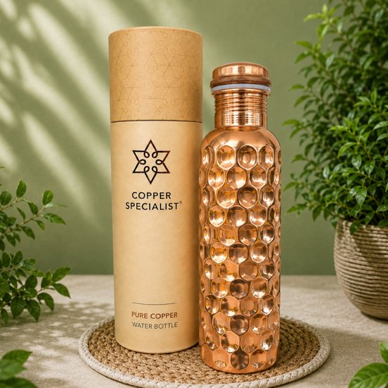 Koperen fles met honingraatstructuur naast een cilindrische verpakking met het 'COPPER SPECIALIST' logo.