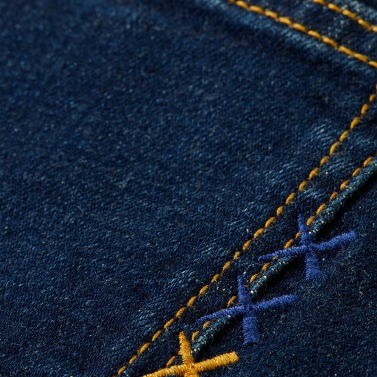 Detail van de donkerblauwe denimstof met gele en blauwe stiksels op een jeans.