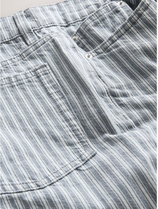 Achterkant van een lichtgrijze denim mom jeans met witte strepen, met achterzakken.