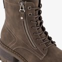 Detail van de rits en veters op een bruine veterboot.