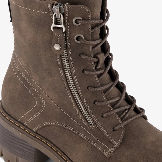 Detail van de rits en veters op een bruine veterboot.