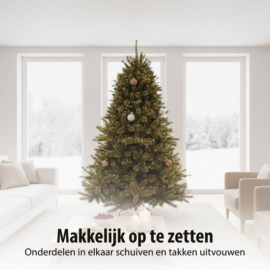 Een groene kunstkerstboom met lichtslingers en kerstballen in een modern ingerichte woonkamer.