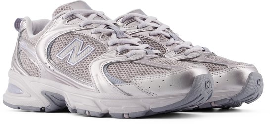 Vue latérale d'une sneaker New Balance 530 gris clair avec des détails argentés.