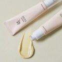 Lichtroze tube met 'Beauty of Joseon' en Koreaanse tekst. Een druppel gele serum is ernaast uitgesmeerd.