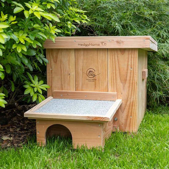 Houten egelhuis met het opschrift "HedgyHome 1.0" en een rond logo met een egel. Het huisje heeft een platform met een boogvormige ingang.