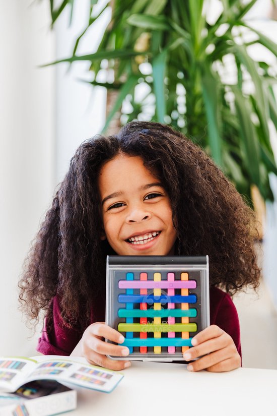 Jong kind met krullend haar houdt een SmartGames IQ Stixx spel vast met gekleurde staafjes.